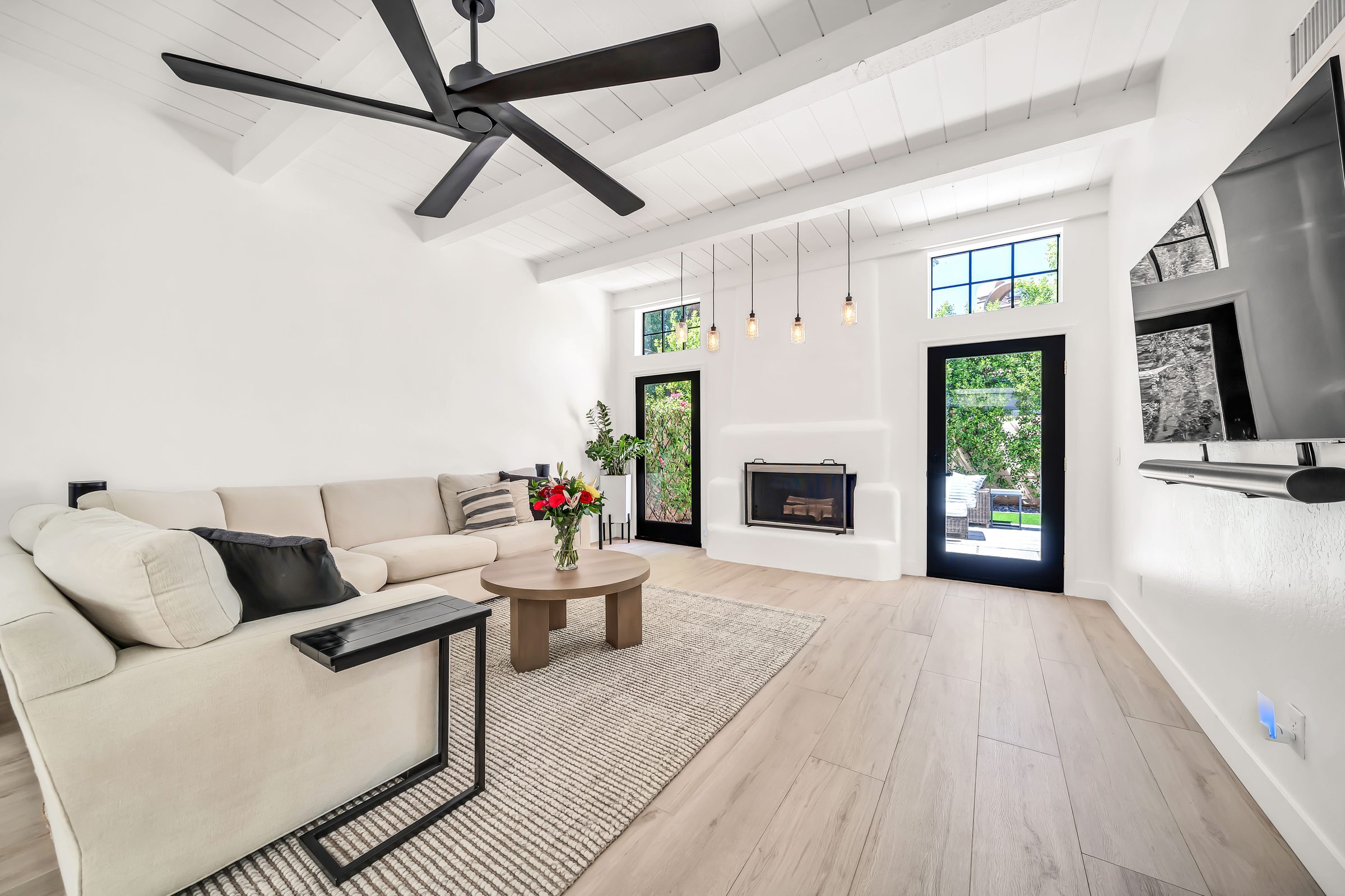 Sunlit great room with fireplace and open patio doors